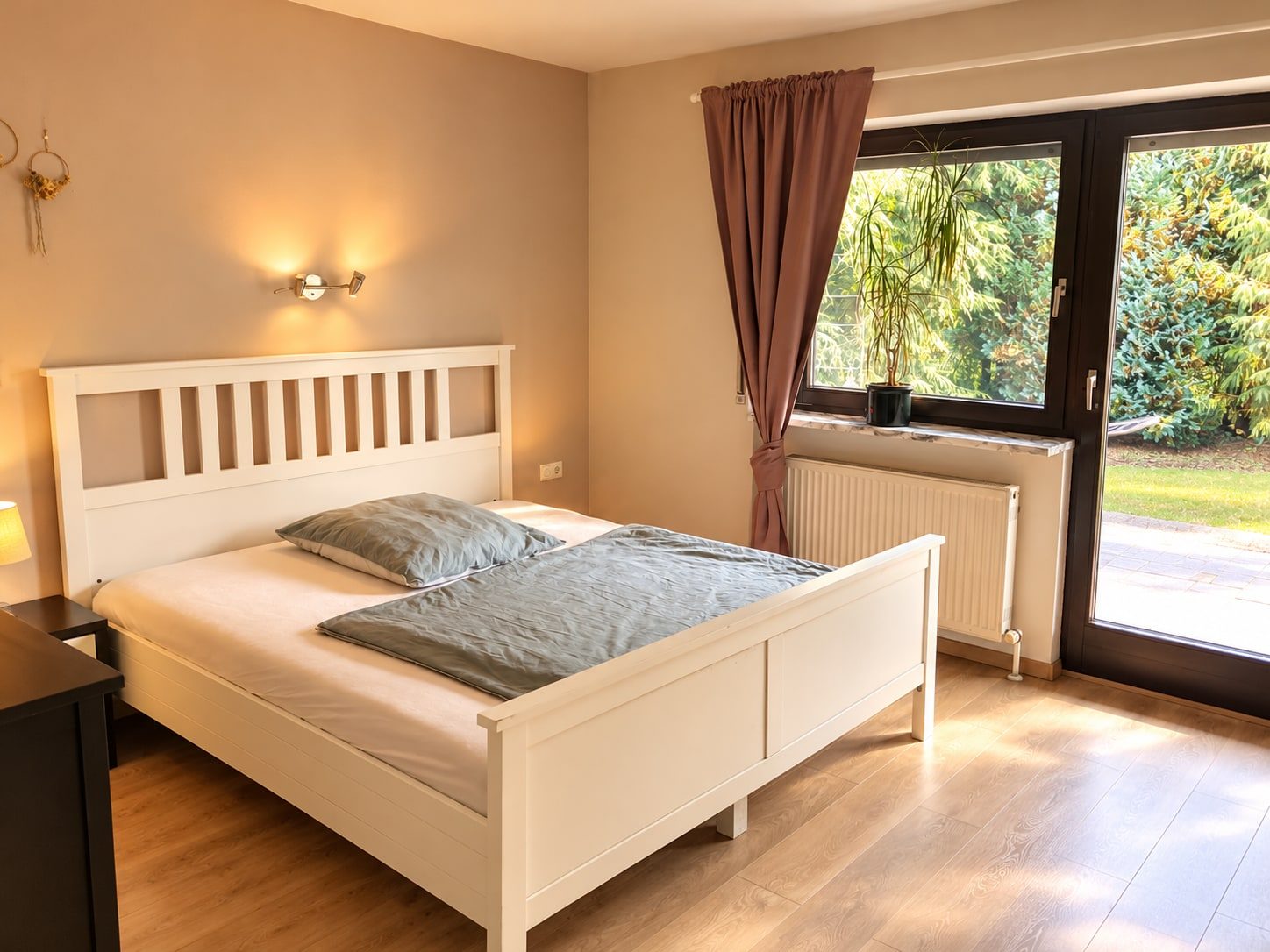Doppelzimmer mit King-Size-Bett und Blick durch die Terrassentür in den Garten